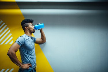 Man consuming a pre-workout supplement before his run outdoors