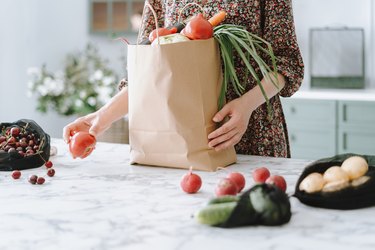 person unpacking vegetables from paper grocery bag for 21-day daniel fast