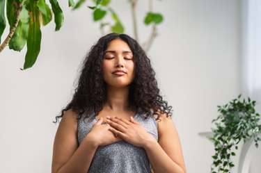 Person putting their hands on their chest and deeply inhaling to cope with a panic attack