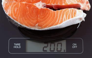 Steak of salmon fish on kitchen scale