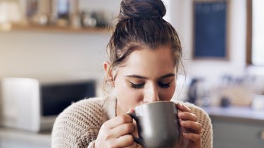 A woman drinking coffee, which makes constipation worse