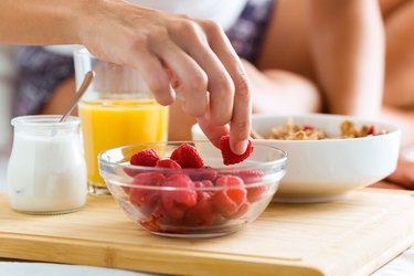 Young woman having breakfast in the bedroom.