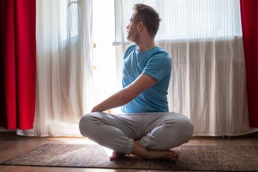 person doing spine twisting pose for digestion