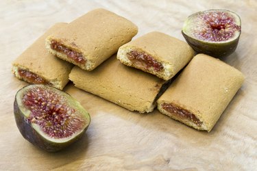 Fig newton-style cookie on a table with fresh figs