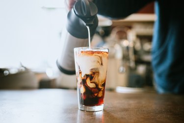 Barista Pours Milk Into Cold Brew Coffee