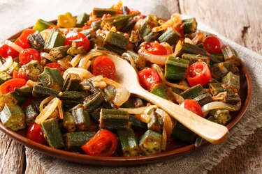 Cooked stew of calcium-rich okra with tomatoes and onion close-up on a plate. horizontal