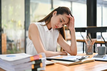 A person sitting at a desk looking stressed