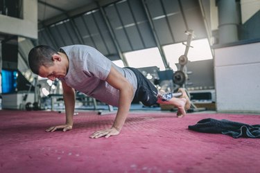 Amputee athlete doing push-ups in the gym as part of a 15-minute body-weight workout