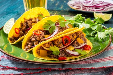 Ground Beef Tacos in hars shell on colorful plate with parsley.