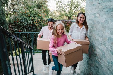 Family carrying boxes up stairs to demonstrate the benefits of stair climbing.