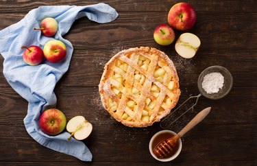 Homemade autumn apple pie on rustic wooden background.