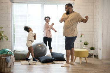 father and his two daughters exercising at home