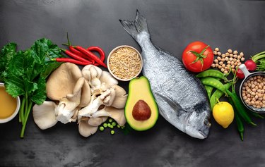 overhead shot of fish, tomato, avocado and more nutritious foods to eat with the epstein-barr virus