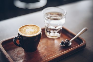 A tray with a cup of water and a mug of coffee, as a way to get over jet lag