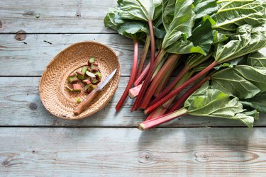 Rhubarb stalks and leaves on wooden table