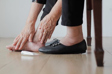 older person putting antifungal cream on feet, as a remedy for athlete's foot