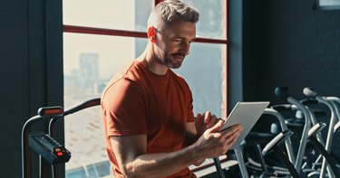 Shot of a handsome mature trainer holding a clipboard and checking the machines in his gym