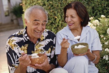 couple eating ice cream in bowls outside in moderation to manage blood pressure