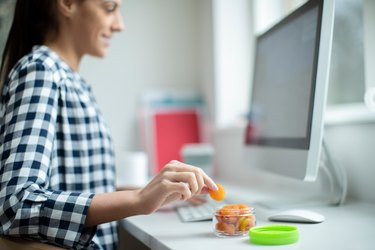 a person working at home having a snack of dried apricots as an example of sodium metabisulfite in foods