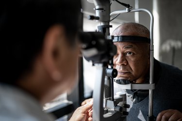 Person getting their eyes examined at the eye doctor, to check for underlying health issues