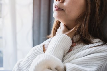 Close view of a woman with a sore throat after drinking