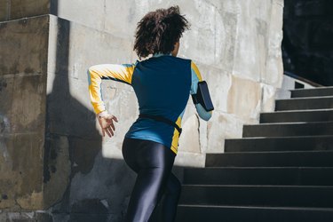 Unrecognizable Woman Sprinting up the Stairs in the City