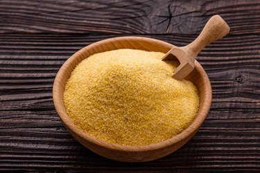 raw Italian cornmeal porridge polenta on a rustic wooden background