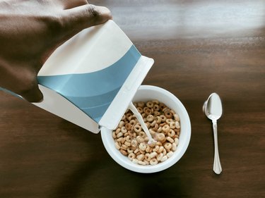 Woman Pours Milk Into Cereal Bowl