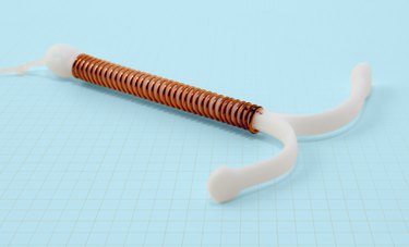 Photo of copper IUD on a light blue background