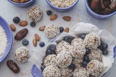 Protein Balls in bowl with almonds, dates and blueberries surrounding