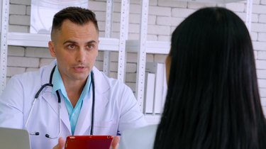 Doctor in professional uniform examining patient at hospital