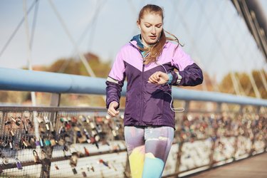 Person running outside checking their watch for speed and distance