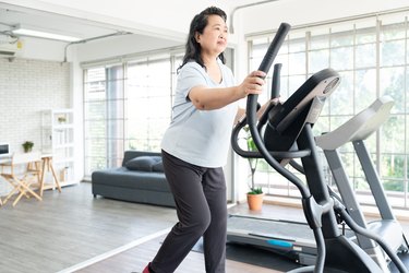 Adult on elliptical in home gym exercising with lupus.