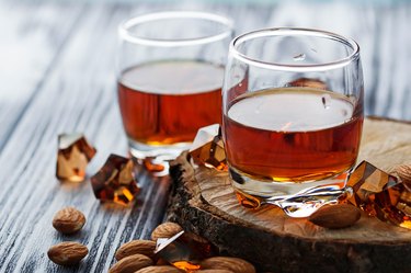 Almond liquor amaretto and almonds on a wooden table