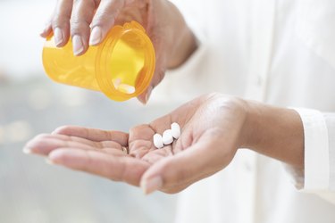 close up of person pouring pills into hand