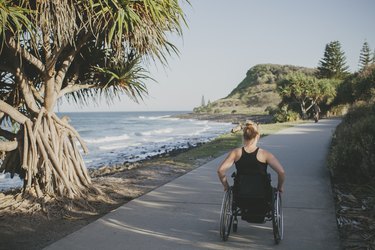 athlete tracking daily activity using wheelchair on a sidewalk by the ocean
