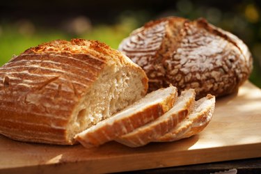 Two rounds of sourdough bread on wooden cutting board