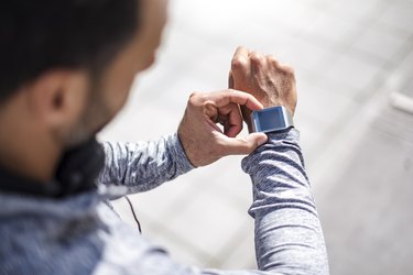 Close-up of  an athlete checking their smartwatch to determine their heart rate when walking slowly