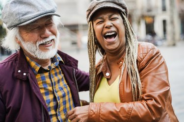 Older couple smiling and laughing outdoors and not thinking "I hate getting old."