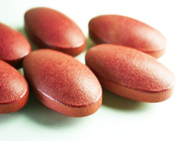close up of red iron tablets on white background