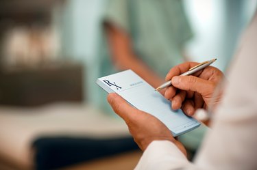 close view of a doctor writing on a prescription pad