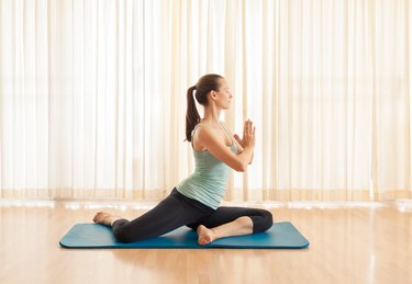 young woman doing a mermaid lift on the floor of her living room