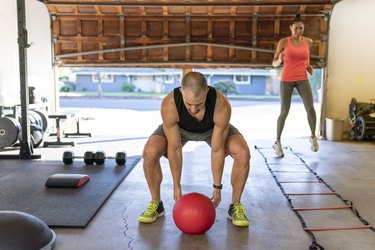 Couple doing cross-training HIIT workout in garage