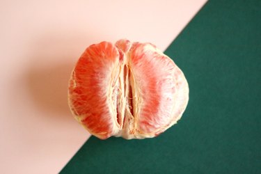 half of a grapefruit on a pink and green background, to represent vagina changes with age