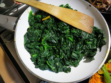 A white pan containing magnesium- and potassium-rich cooked spinach.