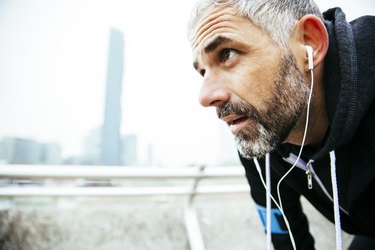 Austria, Vienna, exhausted athlete wearing some of the Best Running Headphones
