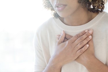 Woman touching her chest because she has shortness of breath