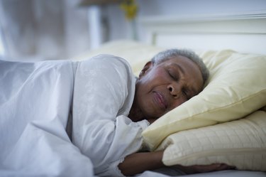 Black woman sleeping in bed, as a tinnitus remedy