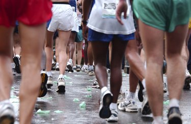 legs and feet of several people walking during a half-marathon