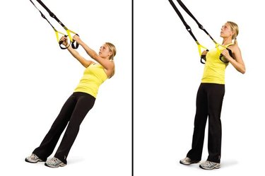 Woman performing low row TRX exercise